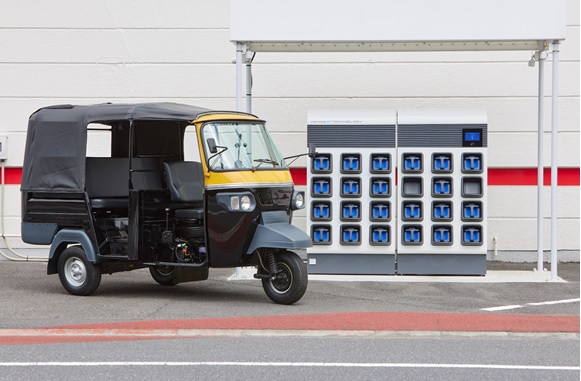 写真　バッテリー交換ステーション「ホンダ・モバイルパワーパック・エクスチェンジャー e:」（右奥）と「E-AUTOリキシャ」（ホンダ提供）