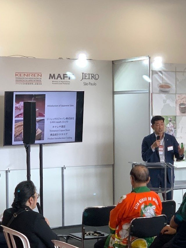 ブラジル・サンパウロ市で開催された 「ふるさといいもの展」で日本酒の説明を行う