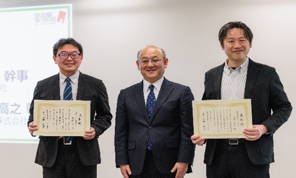 写真 IIPPF中国プロジェクト幹事の大久保淳氏(ヨネックス株式会社)とインターネットプロジェクト幹事の岡崎高之氏(株式会社バンダイ)を、小林利彦座長が表彰
