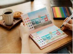 下描きができている画用紙と絵の具、ブラシ、イーゼル機能のハードカバーが絵はがきの形で付いている水彩画キット