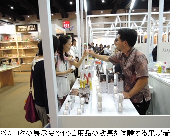 バンコクの展示会で化粧用品の効果を体験する来場者