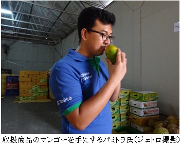  写真　取扱商品のマンゴーを手にするパミトラ氏（ジェトロ撮影）
