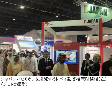 写真　ジャパンパビリオンを巡覧するドバイ副首相兼財務相（左）（ジェトロ撮影）