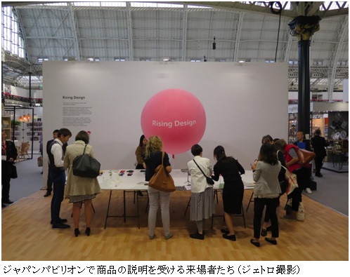 写真　ジャパンパビリオンで商品の説明を受ける来場者たち（ジェトロ撮影）