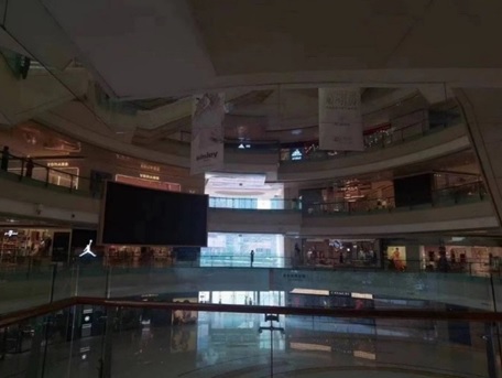 写真　照明も大型スクリーンも消灯している商業施設のエントランスホール（ジェトロ撮影）