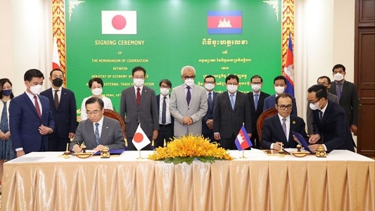 写真　MOCに署名する佐々木伸彦ジェトロ理事長（左手前）とボンセイ・ビソット首相補佐特命相（右手前）（MEF提供）