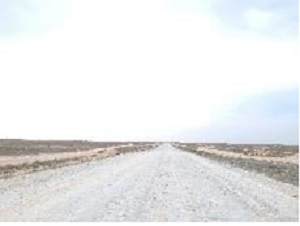 写真　ジャナオゼン～対トルクメニスタン国境間：片道1車線、ジャナオゼン～ケンディルリはアスファルト舗装（良好）、国境手前30キロはアスファルト舗装老朽化による凹凸・砂利道。（トルクメニスタン、ロシア、トルコナンバートレーラーなど）（ジェトロ撮影）