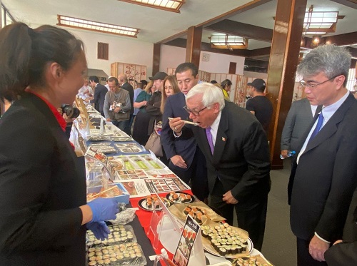 写真　初めて辛子めんたいこを試食するビジャロボス大臣（ジェトロ撮影）