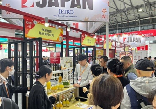 写真　ジャパンパビリオンでの蜜柑ジュース試飲商談の様子（ジェトロ撮影）