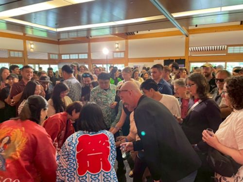 写真　鏡開きの後に振る舞われた酒にも会場中の人が集まった（ジェトロ撮影）