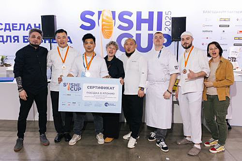 写真　優勝者が持つボードには「日本行きの証明書」と書かれている。左から4番目がインタビューに応じた1人のティシキナ氏（主催者提供）