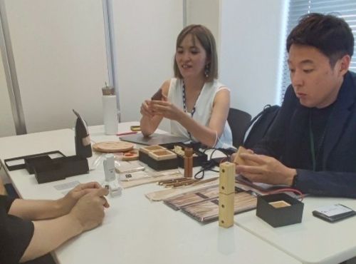 写真　木彫前田工房の商品を手に取る輸出商社の様子（ジェトロ撮影）