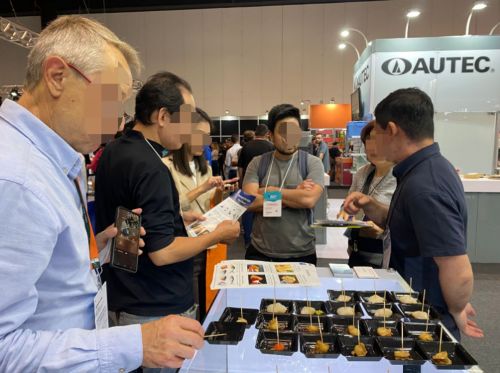 写真　ホタテと明太子を試食する来場者（ジェトロ撮影）