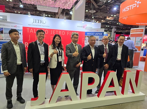 写真　ジャパンパビリオンで記念撮影に応じるガン・キムヨン副首相兼貿易産業相（右から3人目）と石川浩司駐シンガポール日本大使（左から4人目）（ジェトロ撮影、10月29日）