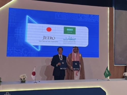 写真　協力覚書（MOU）の披露セレモニーで記念撮影に臨むジェトロ鈴木理事（写真左、ジェトロ撮影）