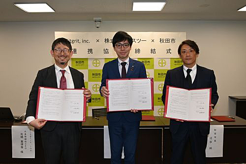 写真　連携協定に署名した、左からBitgritの向縄嘉律哉CEO、秋田市の沼谷純市長、エスツーの須藤晃平代表取締役CEO（秋田市提供）