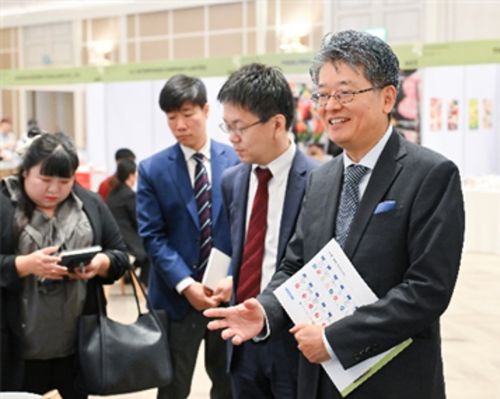 写真　出展者ブースでの意見交換（手前左は阿部ジェトロ・バンコク事務所所長、手前右は原田駐チェンマイ日本総領事）（ジェトロ撮影）