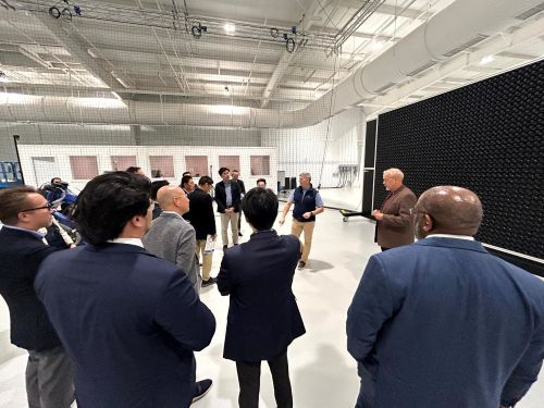 写真　ドローン飛行試験のための巨大送風機前で説明を受ける参加者（ジェトロ撮影）