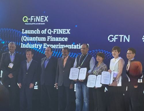 写真　Q-FINEX発足で記念撮影に応じる関係者。GFTNのメノン会長（左から4人目）、GFTNのソピネンドゥ・モハンティ・グループ最高経営責任者（CEO、右から4人目）、UWAのジンボー・ワン教授（右から3人目）（ジェトロ撮影）