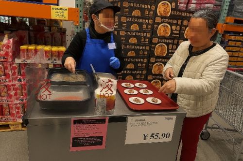 写真　鶏肉の塩胡椒焼きを試食する様子（ジェトロ撮影）